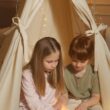 Dziecko czytające kolorową książkę edukacyjną siedzi na podłodze.
