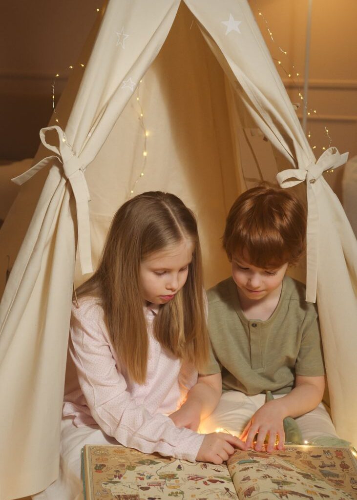 Dziecko czytające kolorową książkę edukacyjną siedzi na podłodze.