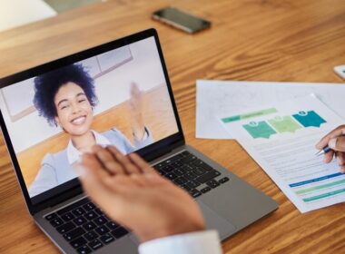 Kobieta pracuje na laptopie z wykresami wynagrodzeń na ekranie.
