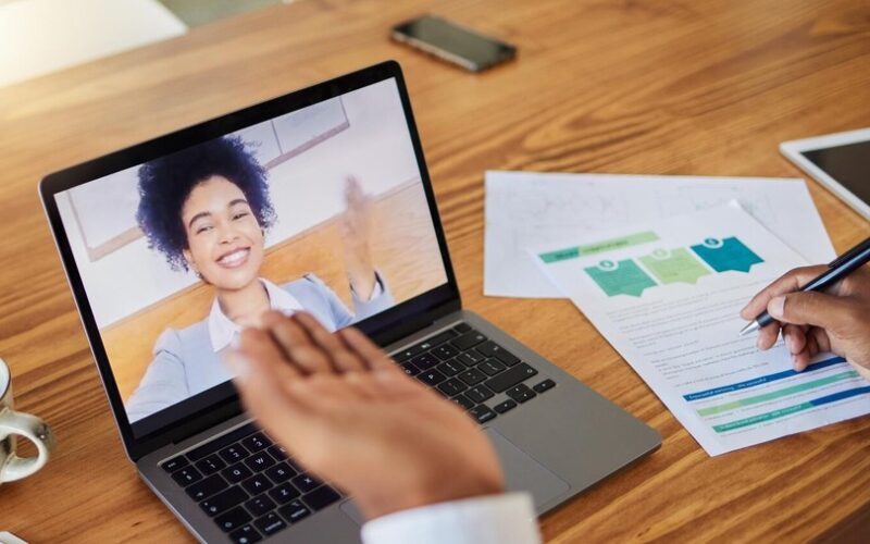 Kobieta pracuje na laptopie z wykresami wynagrodzeń na ekranie.